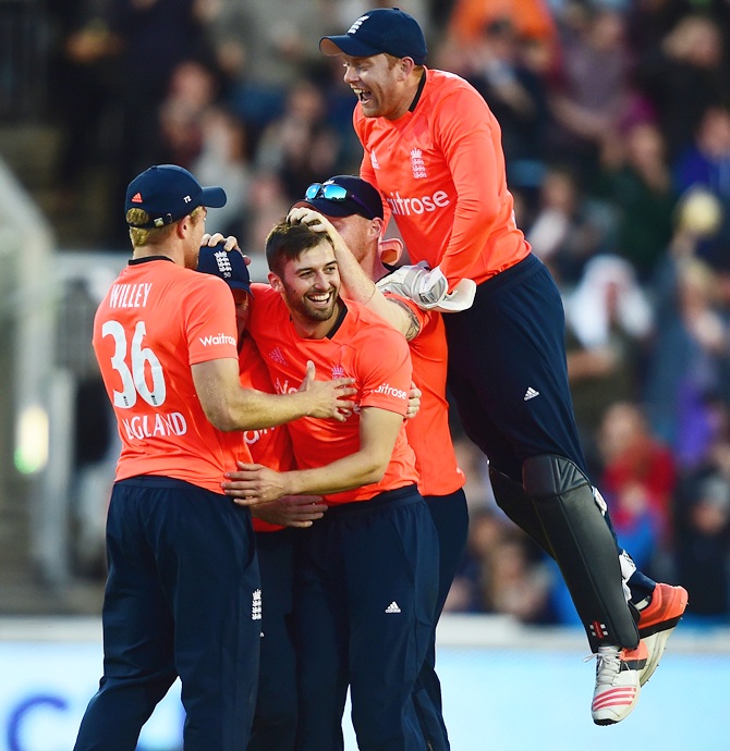England's Mark Wood, centre, celebrates with teammates after taking a wicket