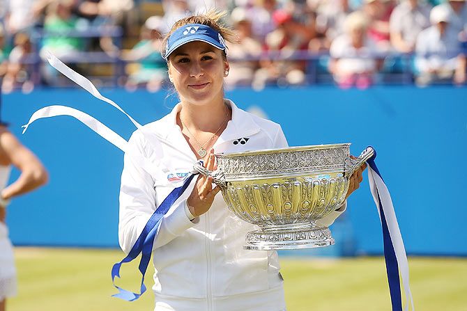 Switzerland'S Belinda Bencic celebrates with the trophy after defeating Poland's Agnieszka Radwanska in the Aegon International final at Devonshire Park in Eastbourne, England, on Saturday