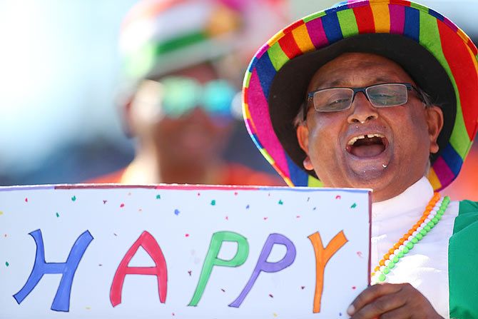 A fan puts out a Happy Holi sign at the WACA