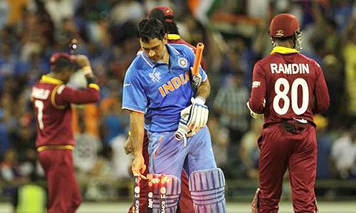 India captain Mahendra Singh Dhoni removes the bails after winning the match against the West Indies on Friday