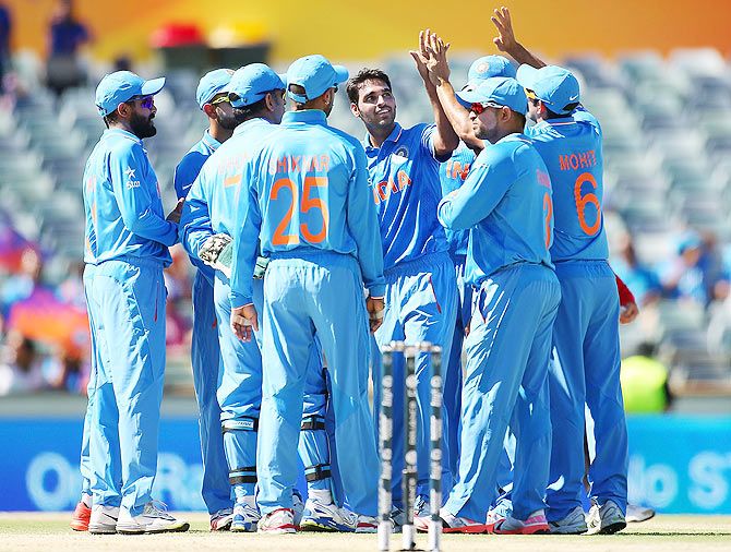 Bhuvneshwar Kumar of India celebrates with teammates after claiming a wicket