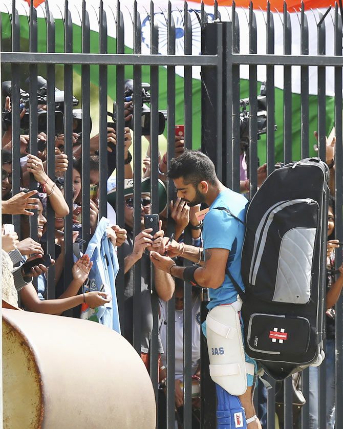 India's batting star Virat Kohli signs autographs for fans during the team's nets session at Sydney Cricket Ground on Wednesday