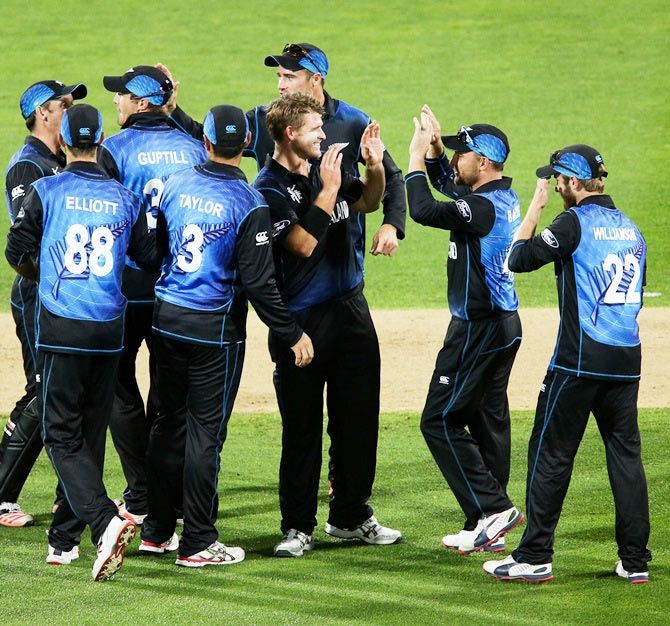 New Zealand's Corey Anderson is congratulated by captain Brendon McCullum and teammates after taking a wicket