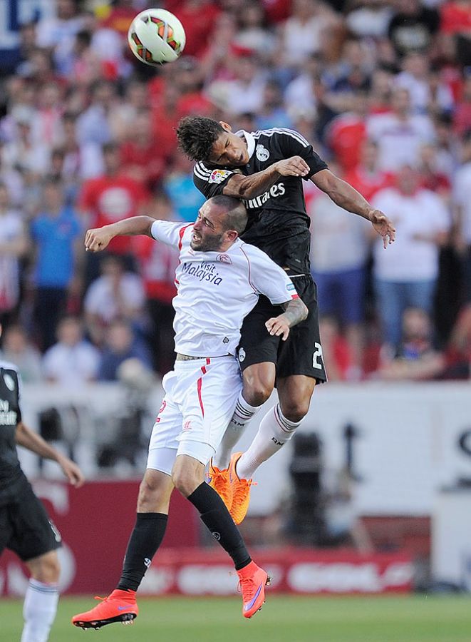 Real Madrid's Raphael Varane battles for the ball with Sevilla's Aleix Vidal