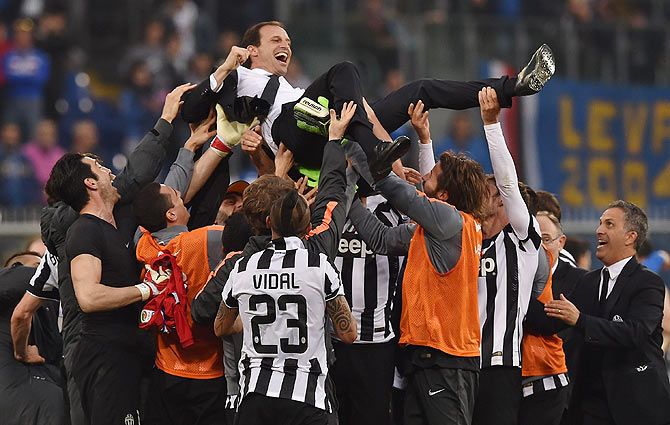 Massimiliano Allegri head coach of Juventus FC is lifted by his players after their title win on Saturday