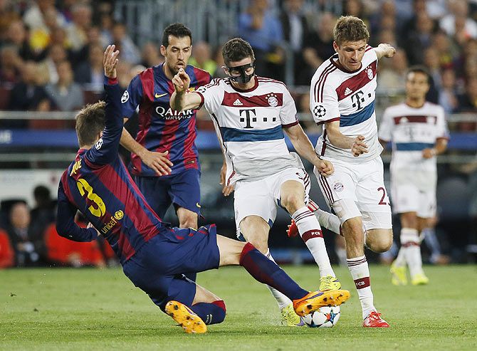 Barcelona's Gerard Pique and Sergio Busquets in action with Bayern Munich's Robert Lewandowski and Thomas Muller