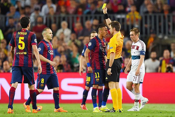 Neymar of Barcelona squares up to referee Nicola Rizzoli as he is shown the yellow card