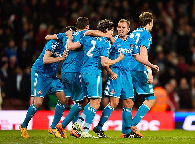 Sunderland's Billy Jones and Lee Cattermole celebrate ecuring Premier League safety with teammates after the match
