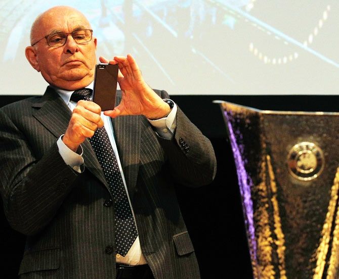 Michael van Praag, KNVB President takes a photo of the Trophy on his mobile phone during the UEFA Europa League trophy handover ceremony