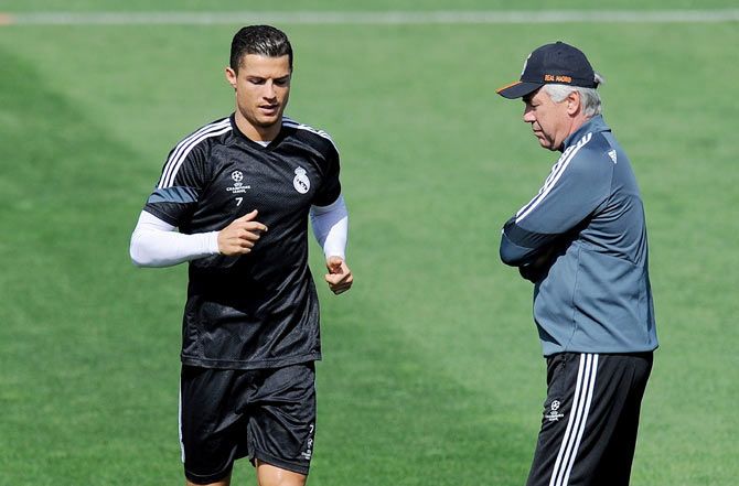 Real Madrid's Cristiano Ronaldo runs past head coach Carlo Ancelotti during a team training session