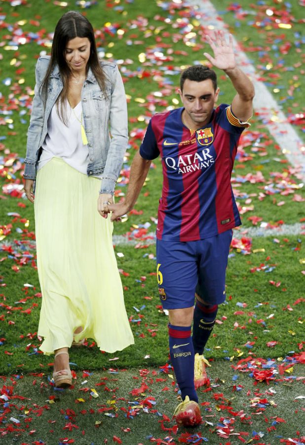 Barcelona's captain Xavi Hernandez waves to the crowd as he leaves the pitch with his wife Nuria Cunillera.