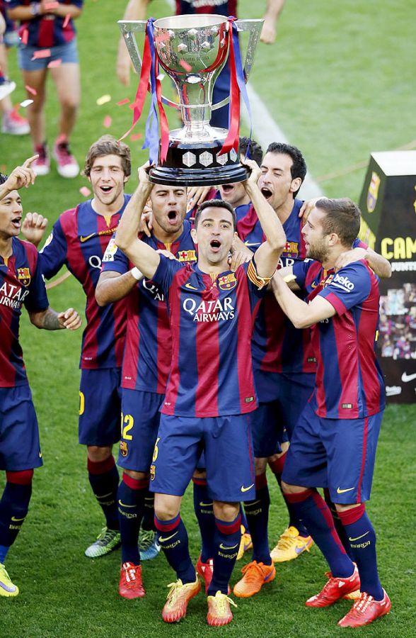 Barcelona's captain Xavi Hernandez raises up the La Liga trophy at Camp Nou stadium in Barcelona on Saturday