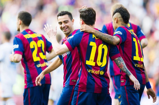 FC Barcelona's Lionel Messi (centre) is congratulated by teammates Xavi Hernandez (left) and Neymar Santos Jr (right) after scoring the opening goal against RC Deportivo La Coruna on Saturday