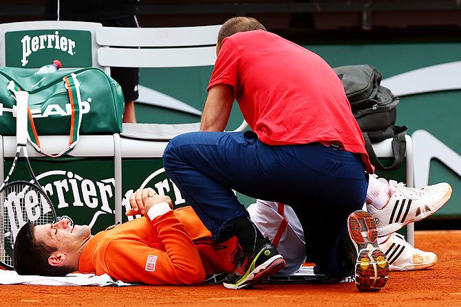 Serbia'S Novak Djokovic receives medical treatment during his men's singles match against Luxembourg'S Gilles Muller on Thursday
