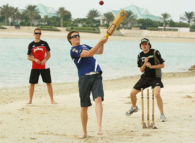 Mark Winterbottom of Ford Performance Racing plays a shot during a game of beach cricket 