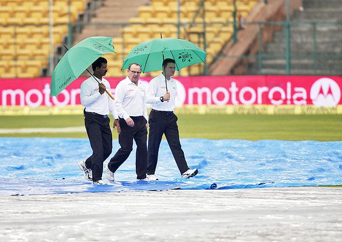 (Left-Right) Umpires CK Nandan, Ian Gould and Richard Kettleborough walk as they inspect the field in Bengaluru