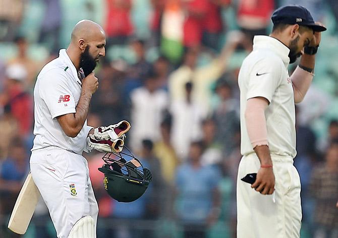 South African captain Hashim Amla and Indian captain Virat Kohli walk out 