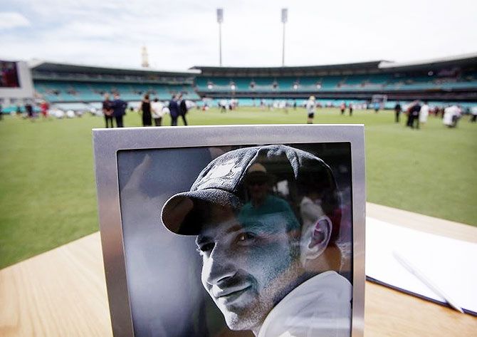 A photograph of Australian cricketer Phillip Hughes is displayed next to a condolences book at the Sydney Cricket Ground