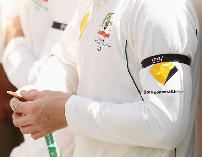  The Australian cricket team wear black arm bands in rememberance of Phil Hughes