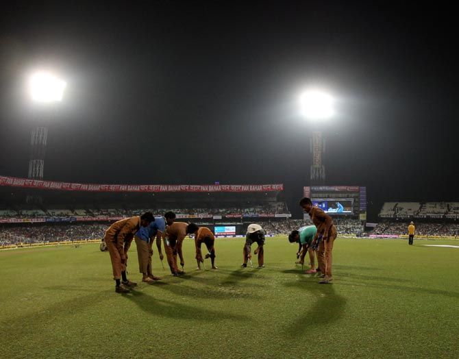 Groundsmen make an attempt to mark the ground for the third and final T20 between India and South Africa at the Eden Gardens in Kolkata.