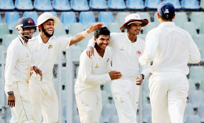 Mumbai's Akhil Herwadkar (centre) celebrates a wicket
