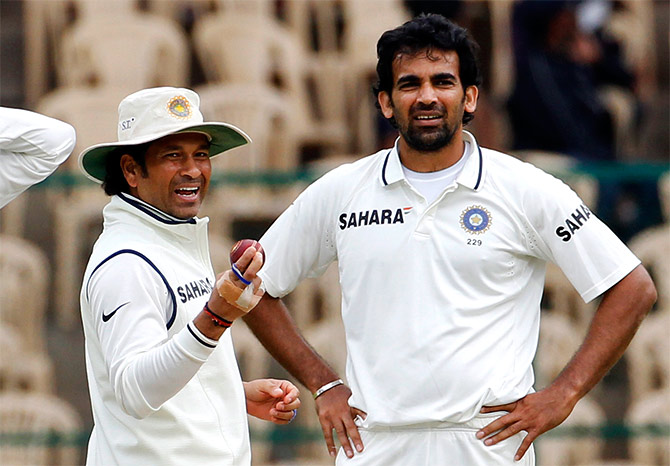 India's Sachin Tendulkar laughs as he holds the ball while standing with teammate Zaheer Khan 