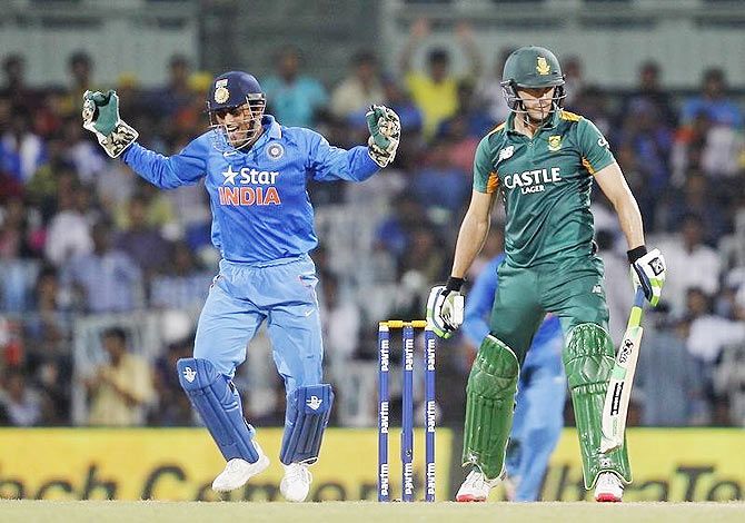 India's captain and wicketkeeper Mahendra Singh Dhoni (left) celebrates after taking the catch to dismiss South Africa's Faf du Plessis during their fourth one-day international cricket match in Chennai on Thursday