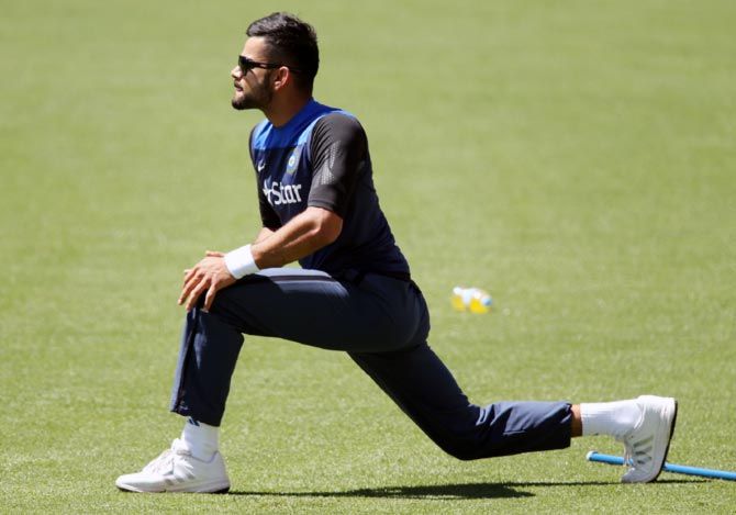 Virat Kohli stretches during a Team India training session