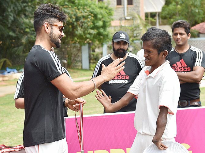 Cricketer Virat Kohli meets a physically disabled young cricketer during an event at RSI ground in Bengaluru on Saturday