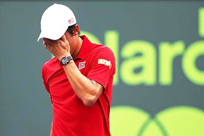 Kei Nishikori reacts after missing a shot against Novak Djokovic 
