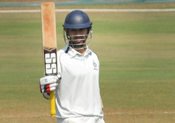 Naman Ojha of Madhya Pradesh raises his bat after scoring a half-century 