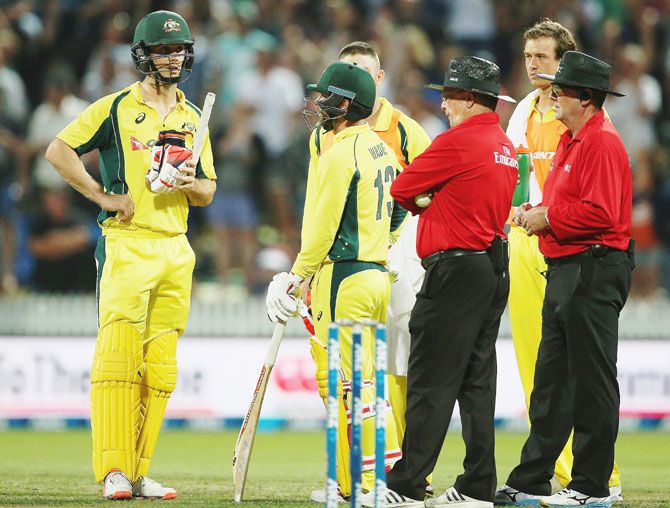 Australia's Mitchell Marsh waits as the umpires watch a replay on the big screen