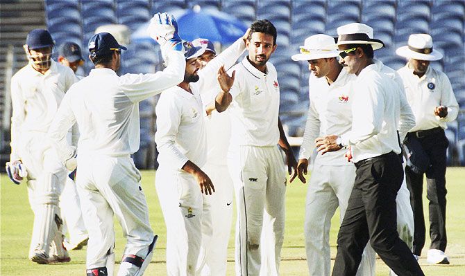 Dhawal Kulkarni is congratulated by his Mumbai teammates after claiming four wickets on the opening day of the Ranji Trophy final against Saurashtra
