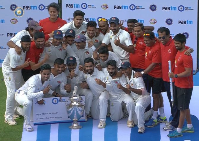 The triumphant Mumbai team poses with the Ranji Trophy after beating Saurashtra by an innings and 21 runs in the final in Pune