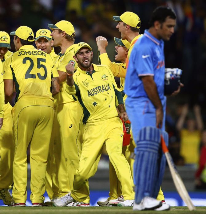 Glenn Maxwell celebrates an Indian wicket as Mahendra Singh Dhoni looks on