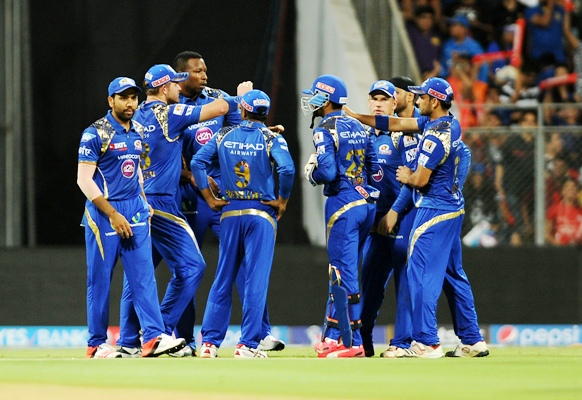 Mumbai Indians' players celebrate the fall of a wicket 