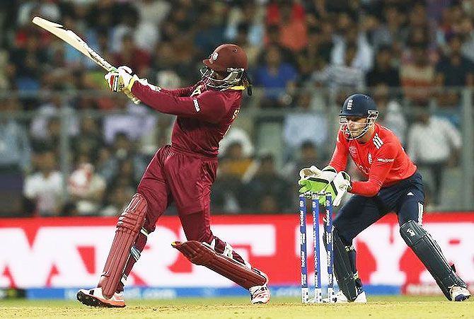 West Indies Chris Gayle (L) plays a shot as England's wicketkeeper Jos Buttler looks on