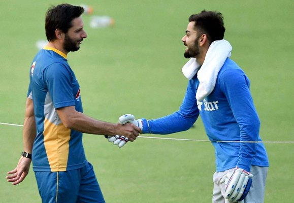 Pakistan's captain Shahid Afridi shakes hands with India's Virat Kohli during their training session at the Eden Gardens