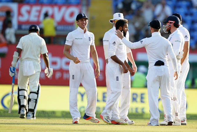 England's Adil RAshid (centre) celebrates with teammates after scalping the wicket of India's Murali Vijay on Day 3 of the first Test match in Rajkot on Friday