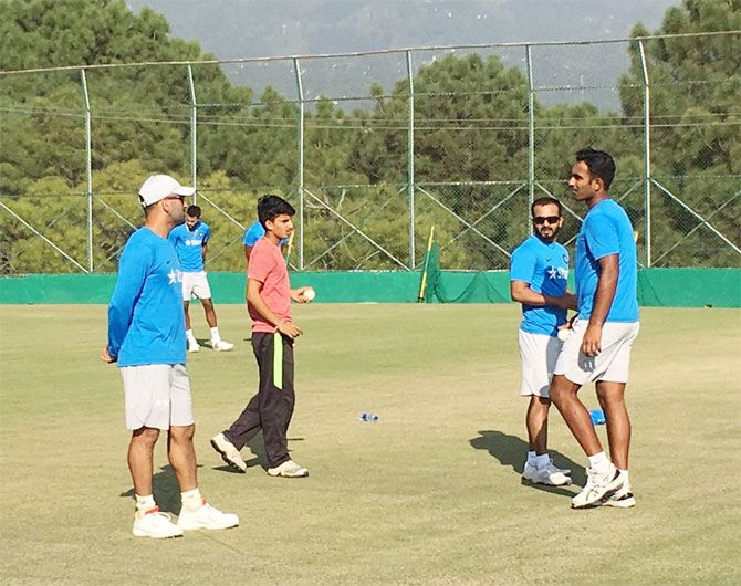 India's One-day skipper Mahendra Singh Dhoni speaks to teammates at a practice session in Dharamsala on Saturday