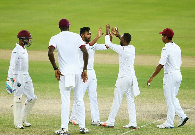 West Indies' Devendra Bishoo celebrates with his teammates after dismissing Pakistan's Sami Aslam on day 4 of the first Test at Dubai International Cricket Ground on Sunday