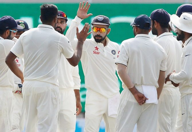 Team India celebrate the fall of a wicket