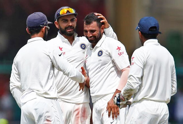 India's Mohammed Shami celebrates with teammates after taking the wicket of New Zealands's Mark Craig on Monday