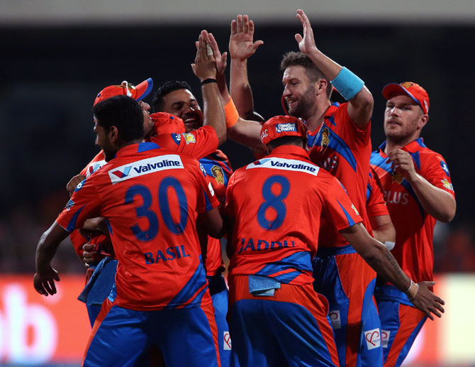 Andrew Tye celebrates with teammates after claiming the wicket of RCB's Travid Head