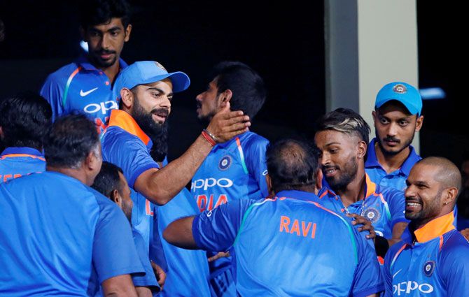 India's captain Virat Kohli celebrates with his teammates at the dressing room after they won the match