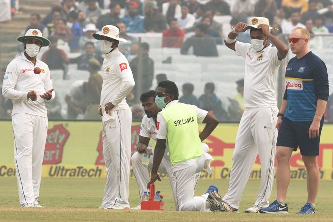 Sri Lanka players and physio wait during the hold up on Day 2 of the 3rd Test at the Feroz Shah Kotla Stadium in New Delhi on Sunday