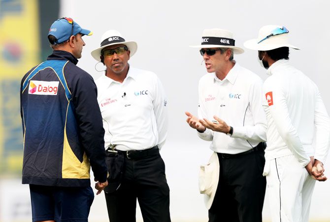 Umpire Nigel Llong speaks animatedly to Sri Lanka coach Nick Pothas as captain Dinesh Chandimal listens in
