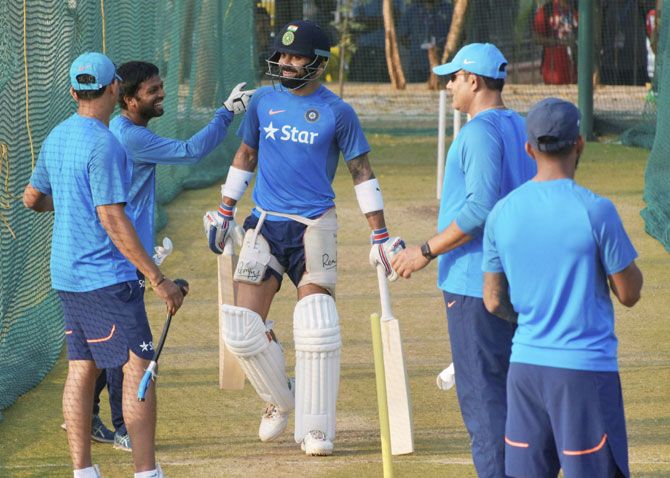 Indian cricket captain Virat Kohli and coach Anil Kumble share a laugh with teammates at a practice session in Hyderabad on Monday