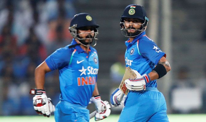 India's captain Virat Kohli (right) and his teammate Kedar Jadhav steal a run during the first ODI against England in Pune on Sunday