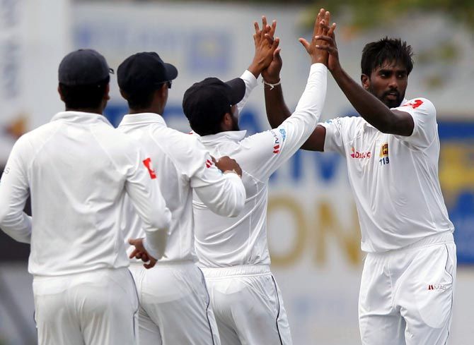 Nuwan Pradeep, right, celebrates with team mates after taking the wicket of Abhinav Mukund